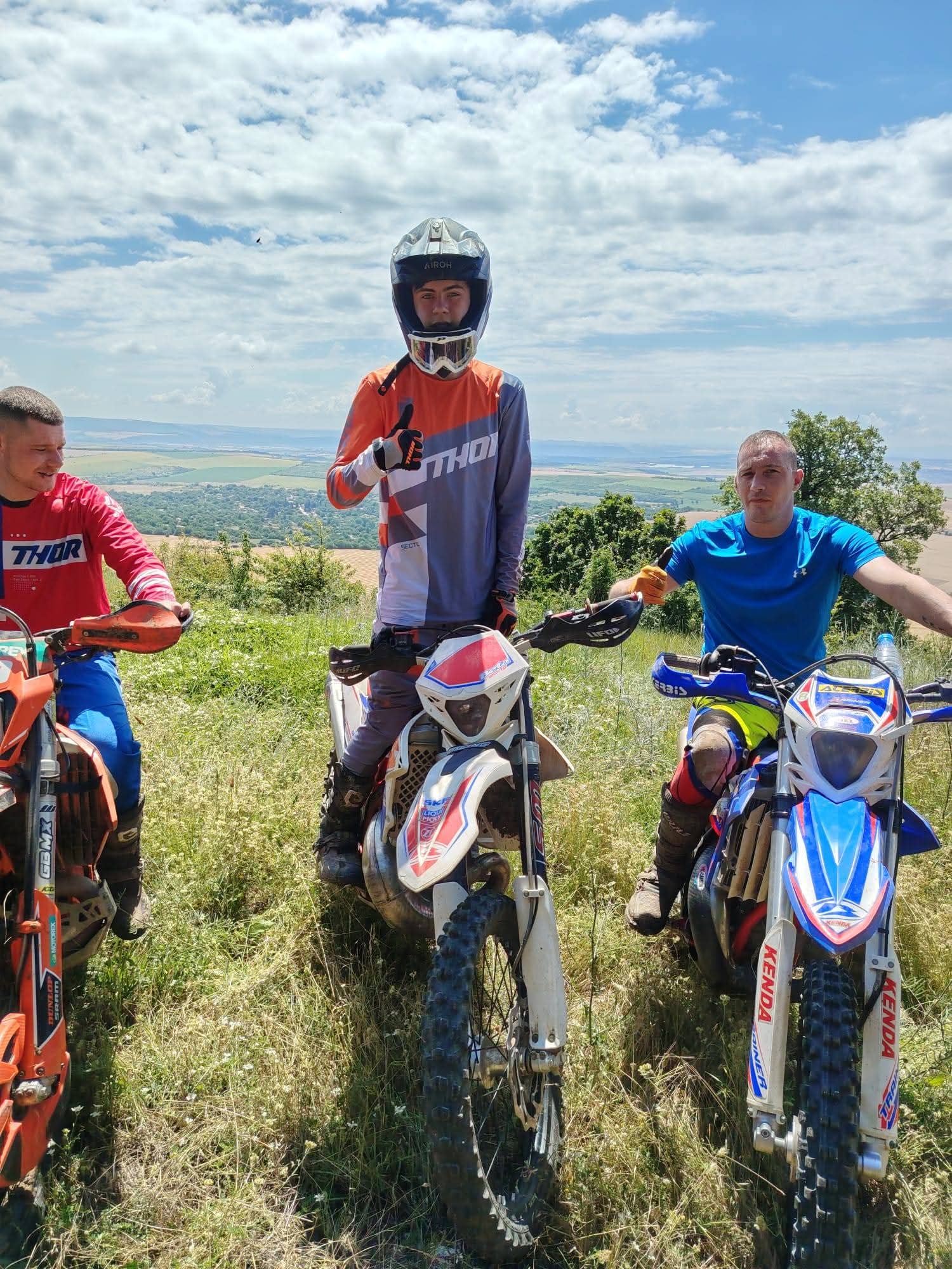 Riders in Thor gear taking a break beside their enduro bikes